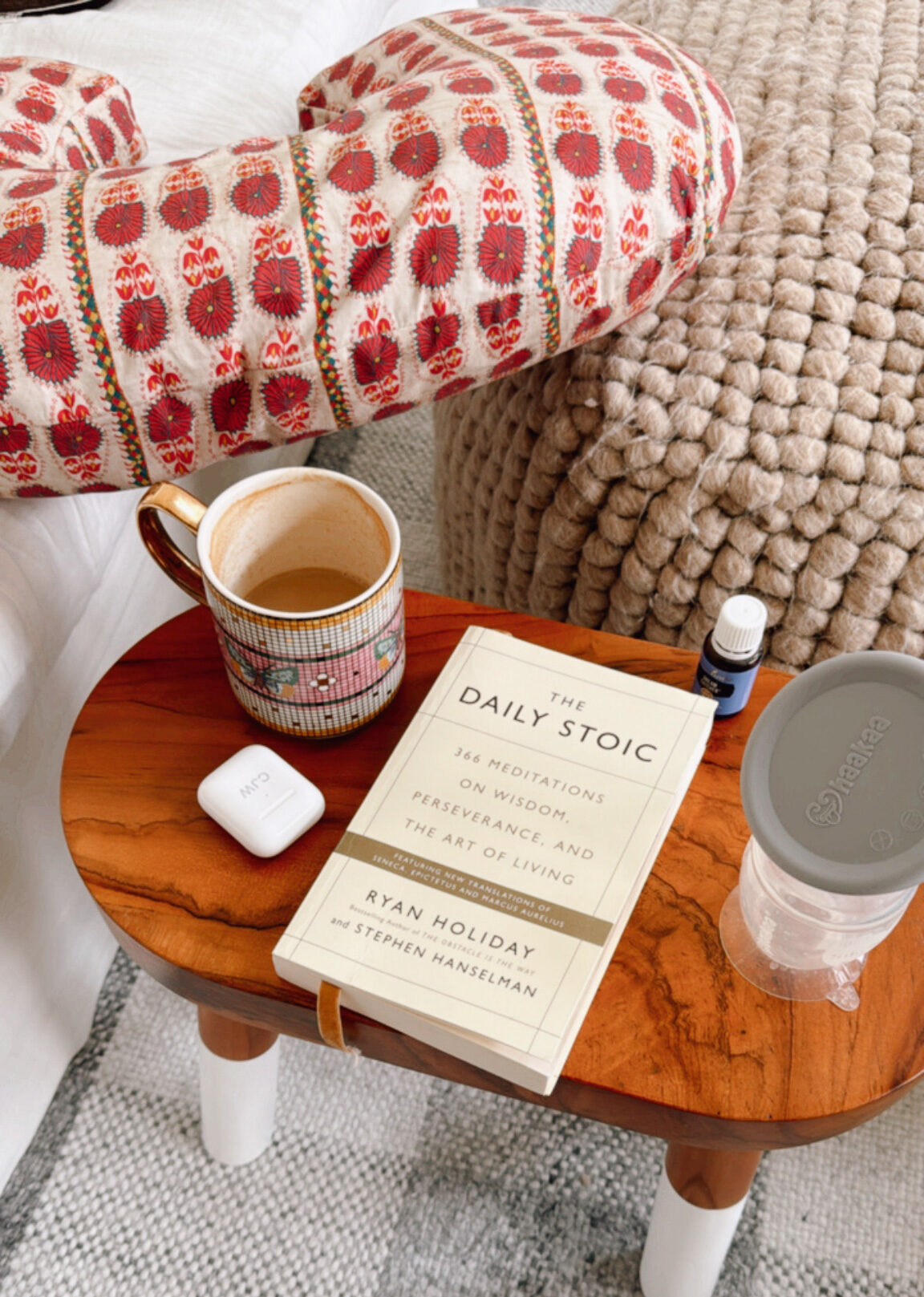 the daily stoic book, coffee, EarPods, hakaa breast pump, boppy pillow in living room