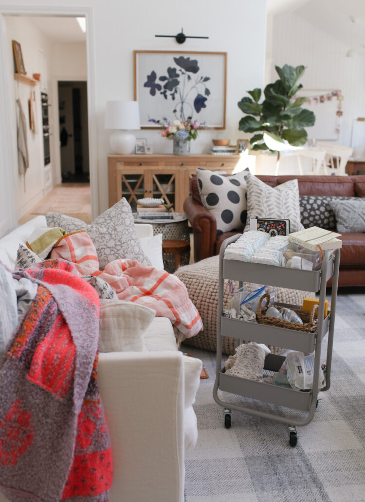 living room with white sofa, leather sofa, diaper cart, Serena and lily gray check rug. design tips to ease post partum depression