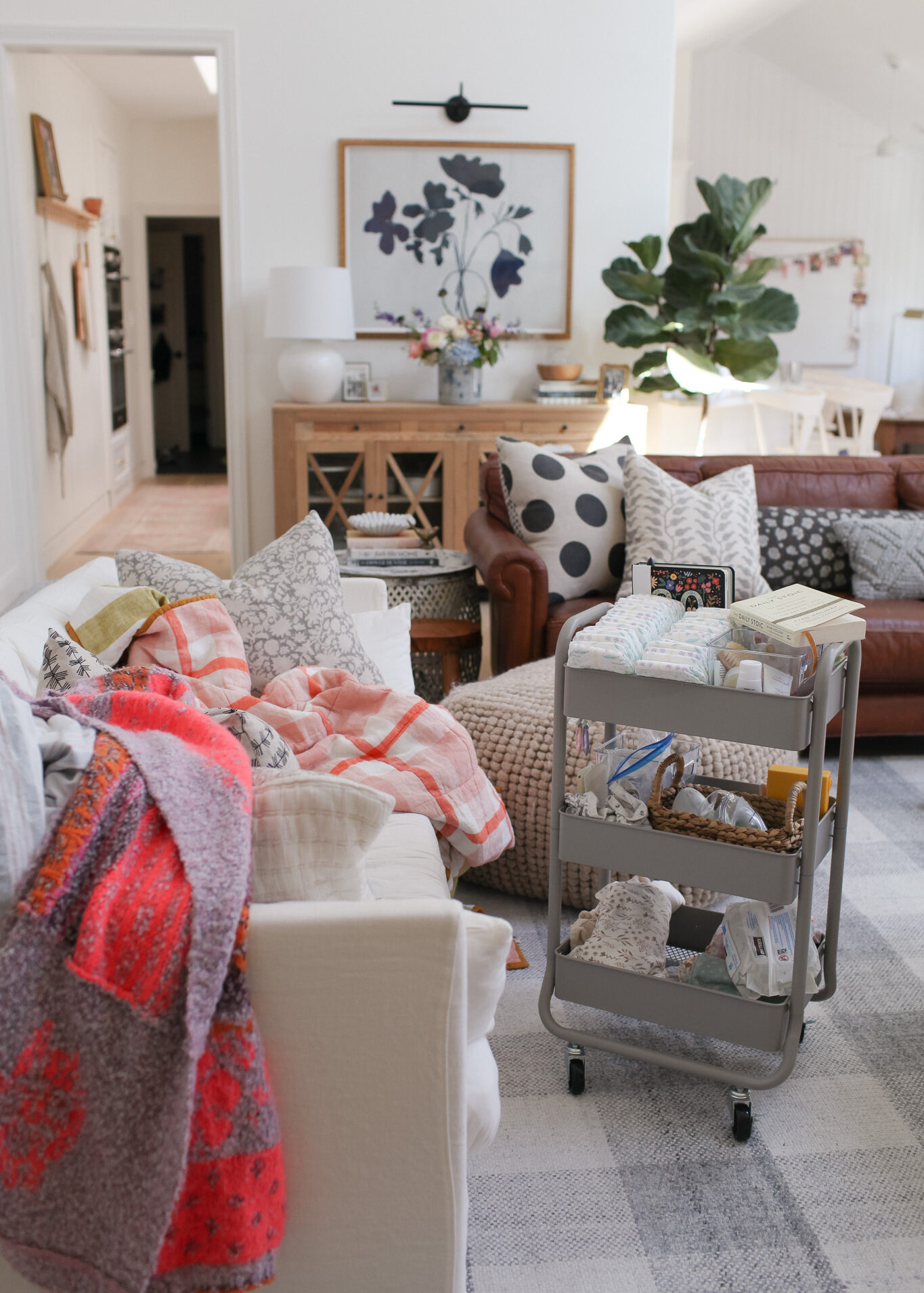 living room with white sofa, leather sofa, diaper cart, Serena and lily gray check rug. design tips to ease post partum depression